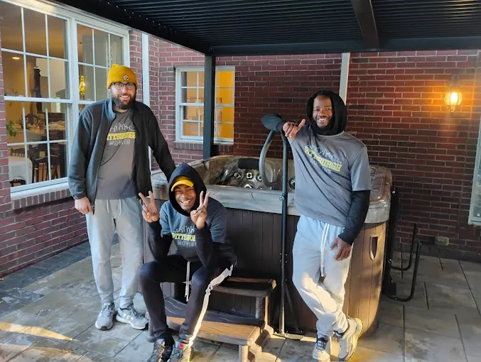 Pittsburgh Moving PGH crew beside a hot tub on a brick patio.